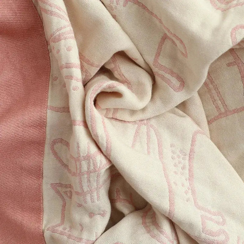 A cream cartoon cat bamboo cotton throw blanket with pink geometric patterns and soft textured fabric for bedroom decorbites decor