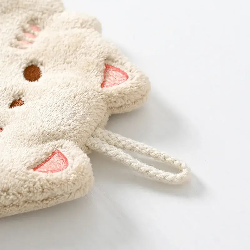 Cream-colored plush cartoon cat hand towel with embroidered pink ears and brown eyes made of microfiber by decorbites