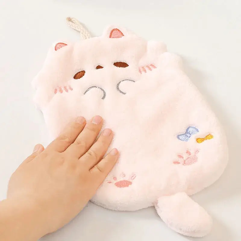 Pink plush cartoon cat hot water bottle with embroidered face and paw prints alongside decorbites cartoon cat hand towel