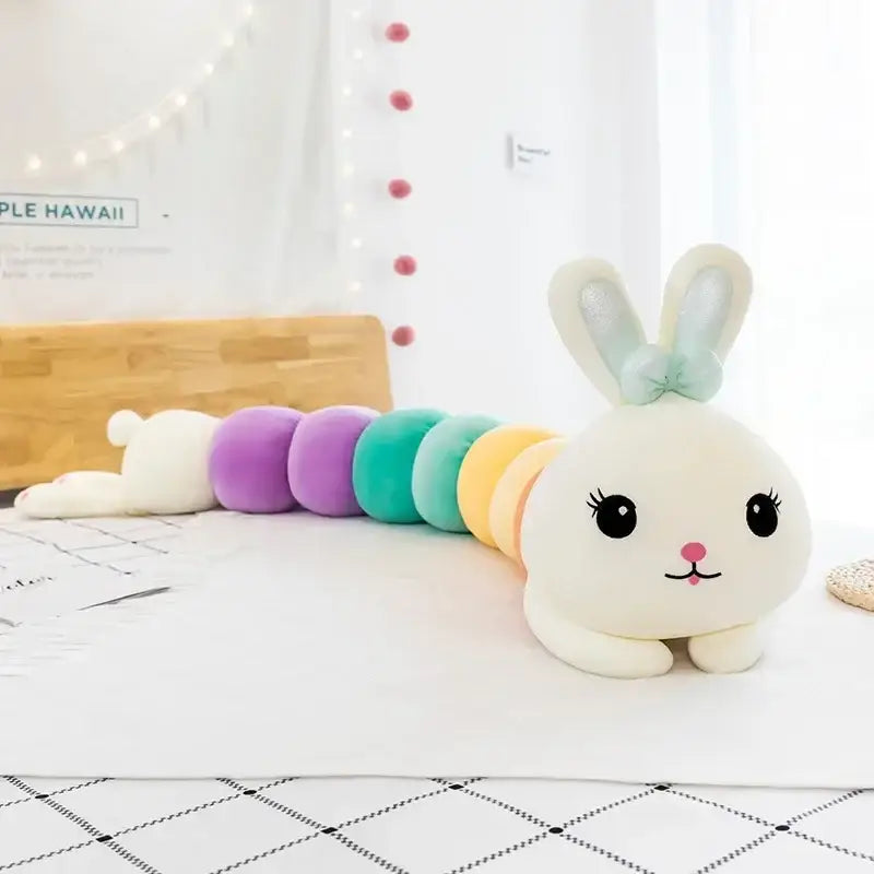 A plush cartoon caterpillar long body pillow with a white bunny face and pastel orange and green segments for bedroom use