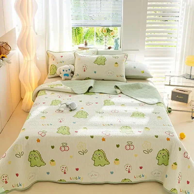 Cute green dinosaur-themed quilted bed cover set made of soft cotton with playful patterns on an off-white background