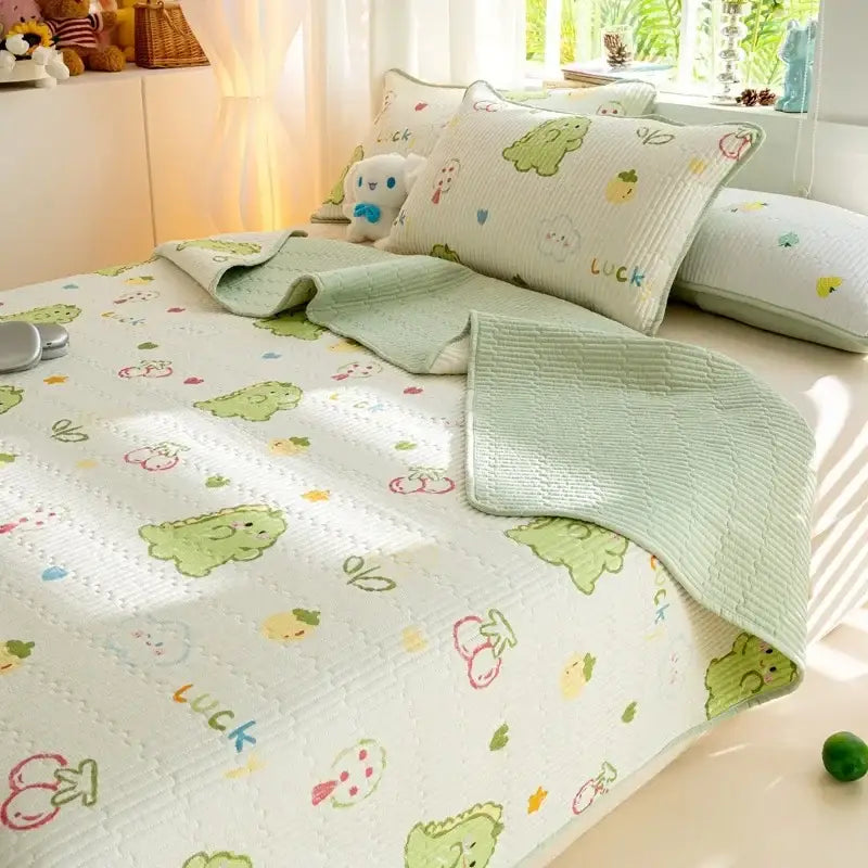 Light green and white cotton quilted bed cover set with playful cartoon dinosaurs cherries and luck lettering pattern