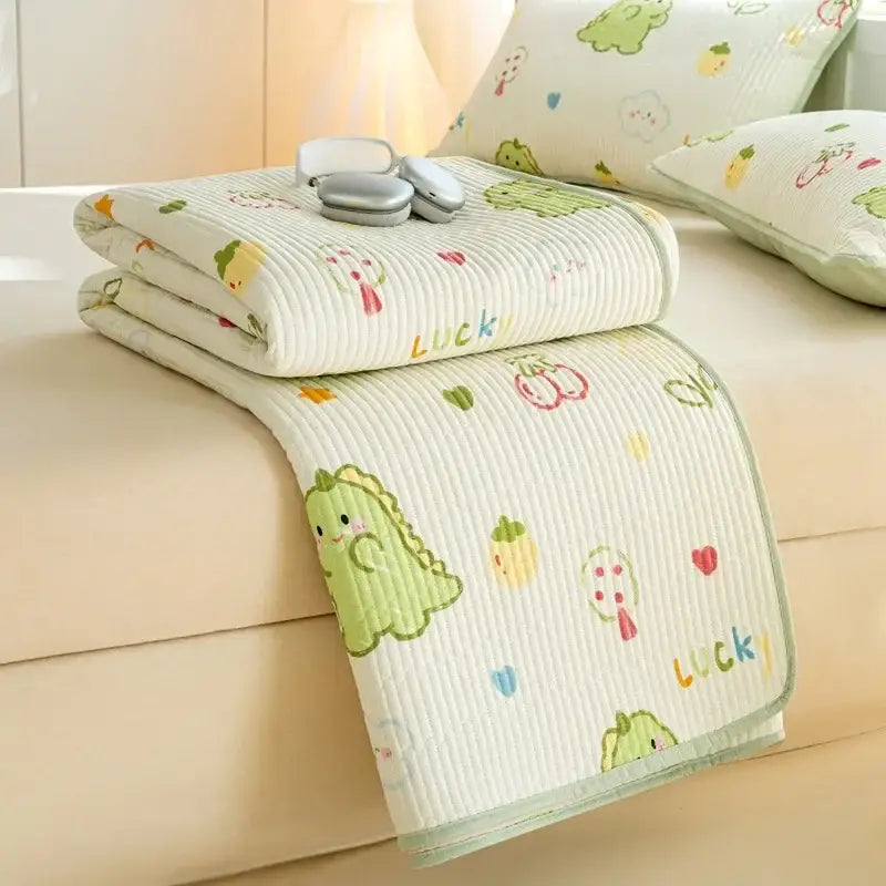 A cream-colored cartoon dinosaur green quilted cotton bed cover set with playful fruit patterns and lucky lettering