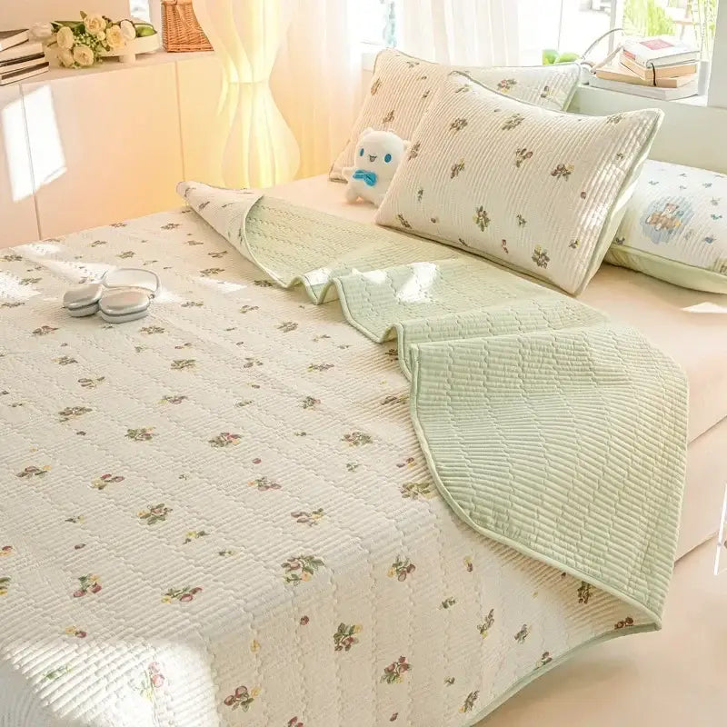 A soft light green cotton quilted bed cover set with delicate floral pattern for bedroom use
