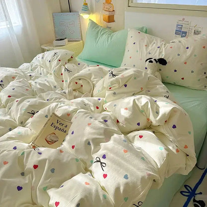 Cream cotton fitted sheet set with cream-colored duvet featuring multicolored hearts and black bow details