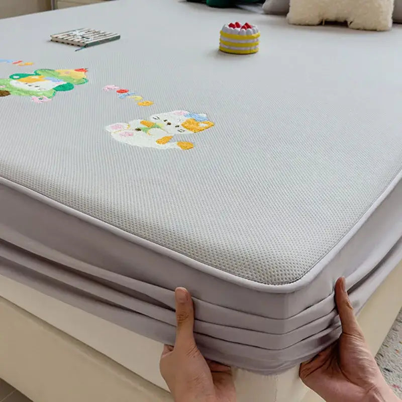 Light gray fitted sheet with decorbites cartoon embroidered mesh bed pad and soft stretchy border for mattress protection