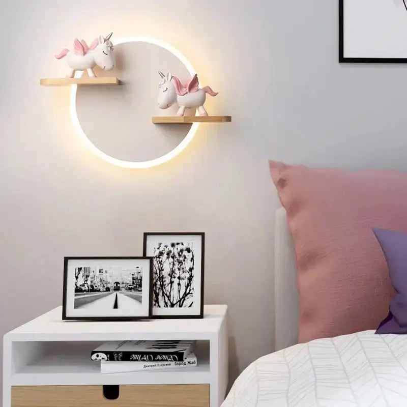 Cartoon figurine led wall lamp with circular warm led wall lamp and wooden shelves holding pink and white unicorns