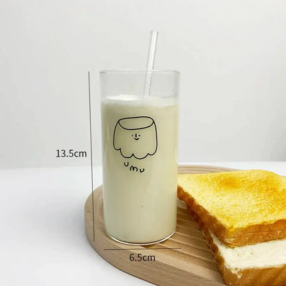 Clear glass cup with a minimalist black cartoon glass cup design filled with creamy milk and a transparent straw