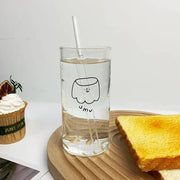 Clear glass cup with black line marshmallow drawing and yum text filled with water and clear straw decorbites cartoon glass