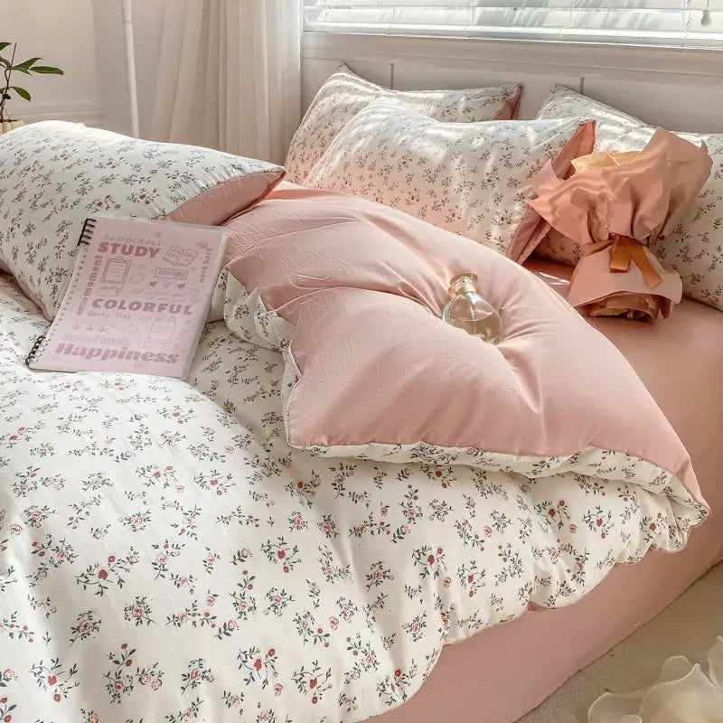 Pink floral-patterned quilted duvet set with matching pillowcases featuring cartoon heart floral design