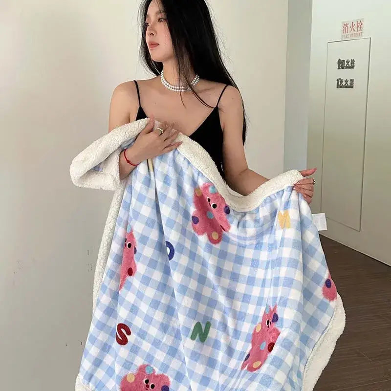 A cozy light blue and white checkered decorbites cartoon lamb wool blanket with pink bear appliqués and fleece lining