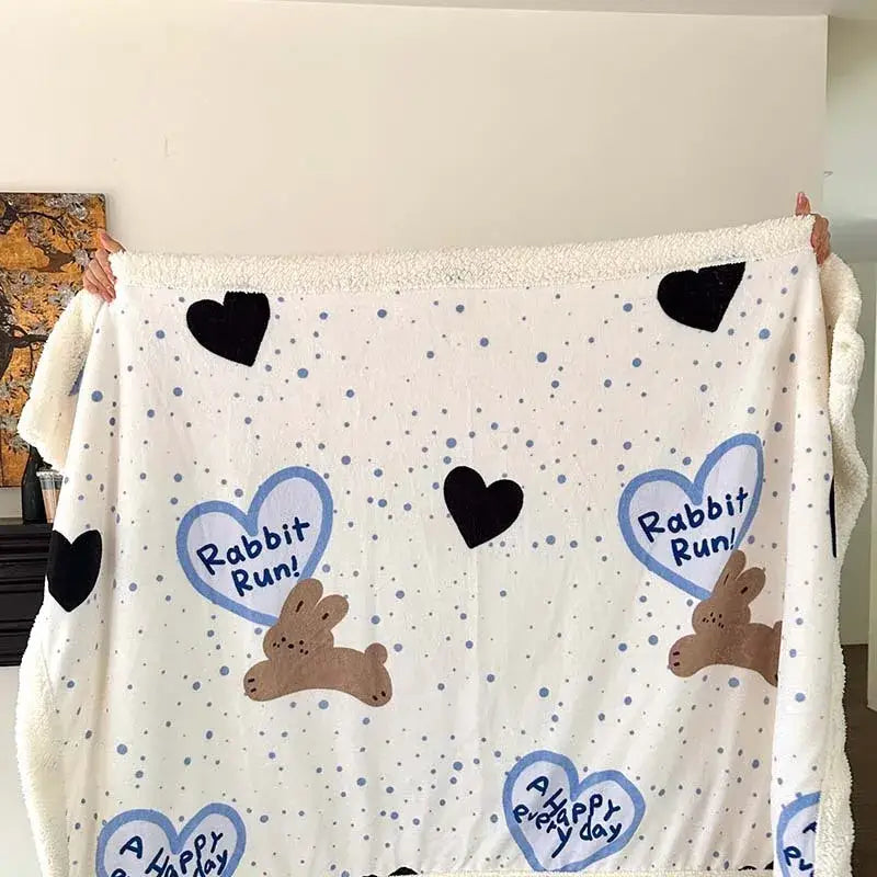 Cream-colored plush cartoon lamb wool blanket with brown rabbits and blue hearts for cozy bedroom decorbites use