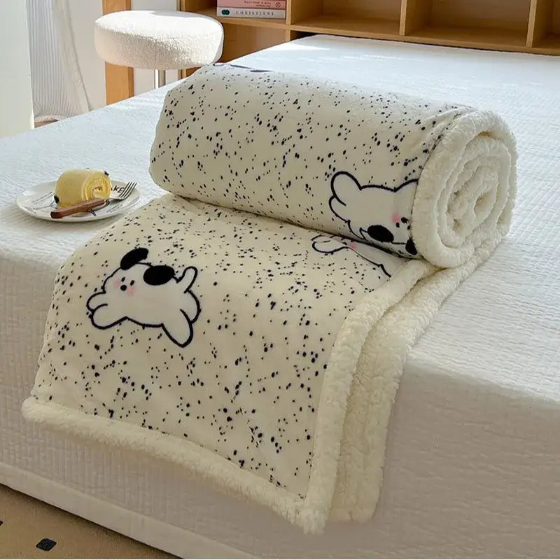 Cream-colored cartoon lamb wool blanket with black speckles and cartoon dog illustrations soft fleece texture
