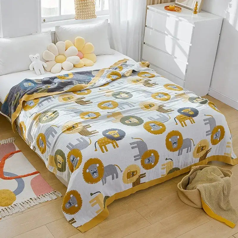 A soft white cartoon lion cotton throw blanket with yellow gray playful lion and elephant pattern and mustard border