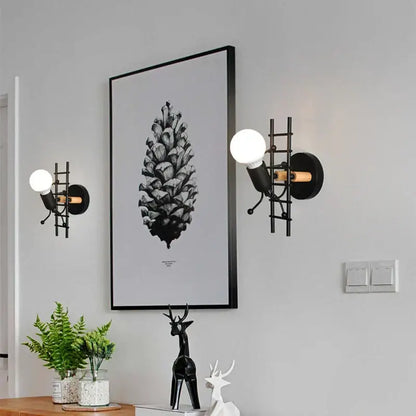 Black metal wall lamp with ladder design and exposed bulb cartoon matchstick man decorbites kids room sconce