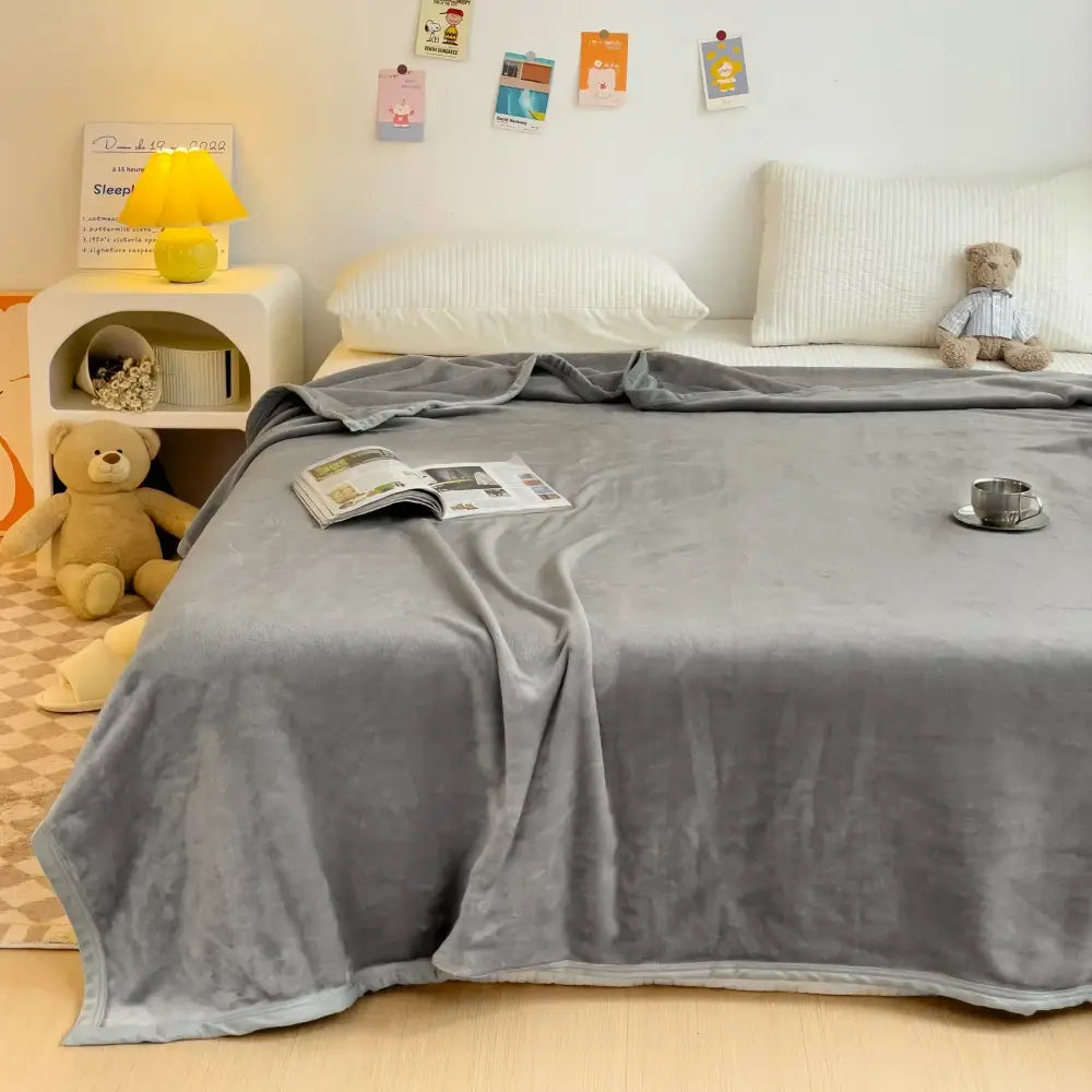 Soft gray plush decorbites cartoon milk velvet blanket with subtle sheen draped over bed in white floral bedroom decor