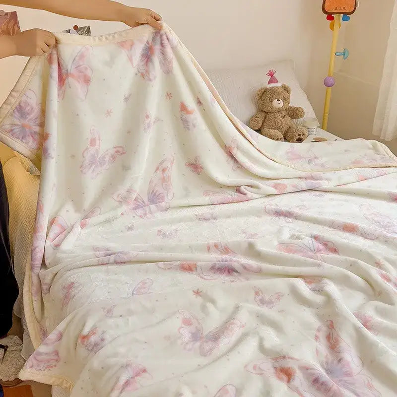 A cream-colored decorbites cartoon milk velvet fleece blanket with pastel pink and lavender butterfly pattern for bedroom decor