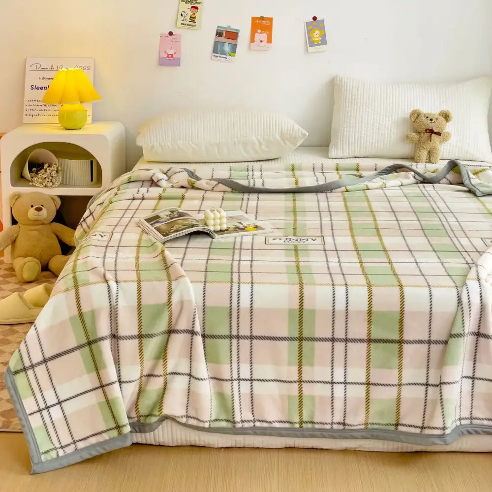 Cartoon milk velvet teddy bear blanket in soft pastel green and cream plaid with a cozy textured fleece finish