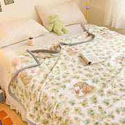 A soft white cartoon milk velvet teddy bear blanket with green and blue floral pattern for bedroom decorbites decor