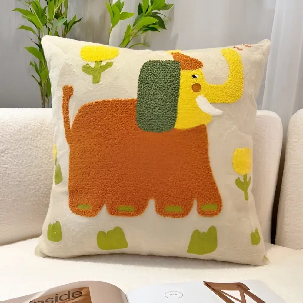 A cozy cream-colored throw pillow with cartoon oil painting embroidery of an orange elephant and green flowers for decorbites cartoon oil decor