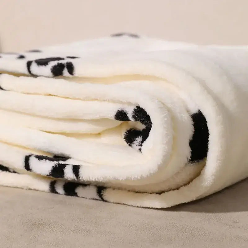 A plush white cartoon panda flannel fleece blanket with black panda faces and pom poms for bedroom decorbites decor
