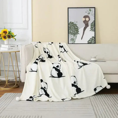 A soft white cartoon panda flannel fleece blanket with black panda silhouettes and pom poms for bedroom decorbites cartoon panda