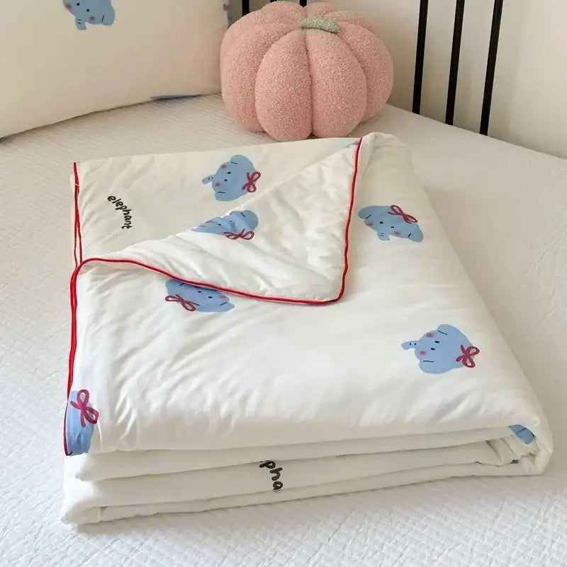 A soft white cartoon patchwork summer cooling blanket with light blue elephant prints red bows and red piping edges