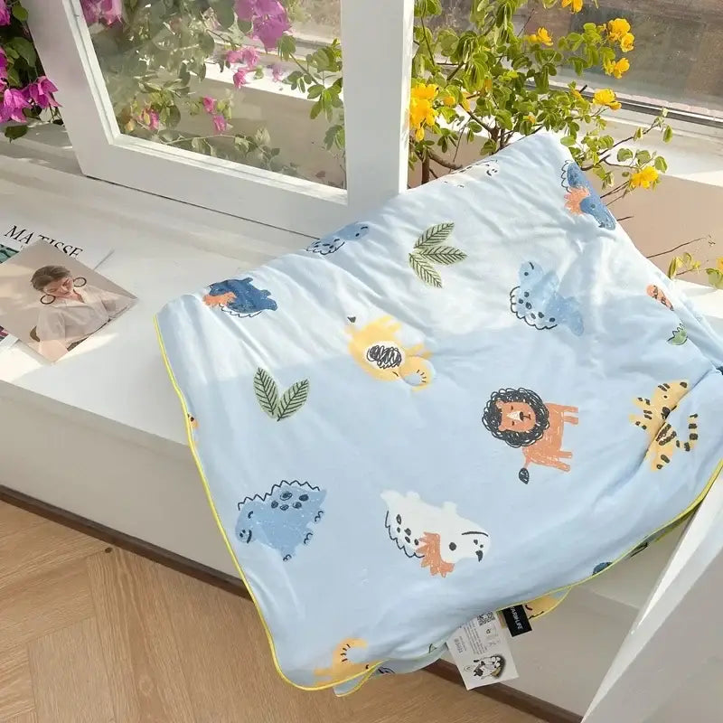 Light blue quilted decorbites cartoon patchwork summer blanket with playful animal patterns and yellow trim for bedroom comfort