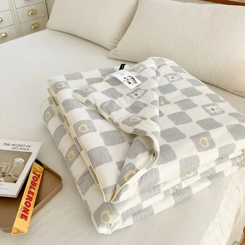 A soft gray and white checkered quilt with small embroidered hearts from the decorbites cartoon patchwork summer collection