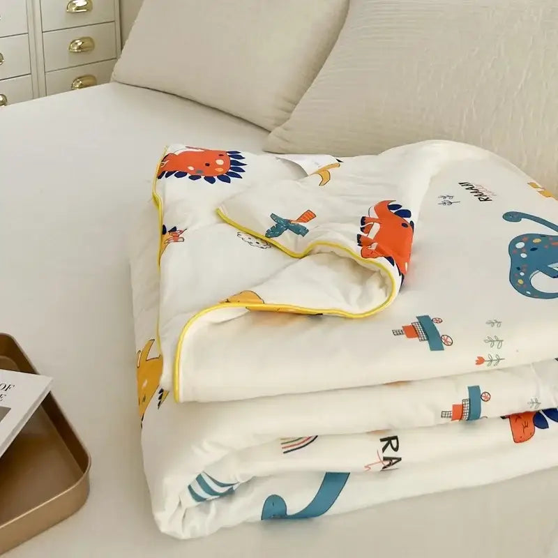 White cartoon patchwork summer cooling blanket with colorful dinosaur and train prints and yellow border by decorbites