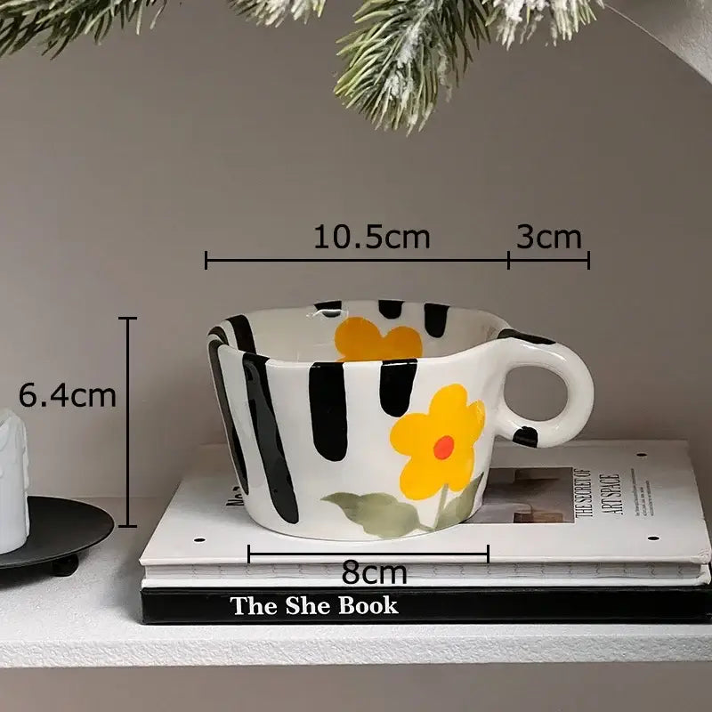 A white ceramic cartoon pattern ceramic coffee mug with bold black stripes and a yellow flower for kitchen decorbites
