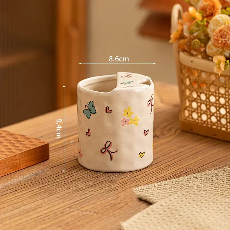 A charming off-white cartoon pattern porcelain toothbrush holder with colorful butterflies hearts and bows for bathroom decor