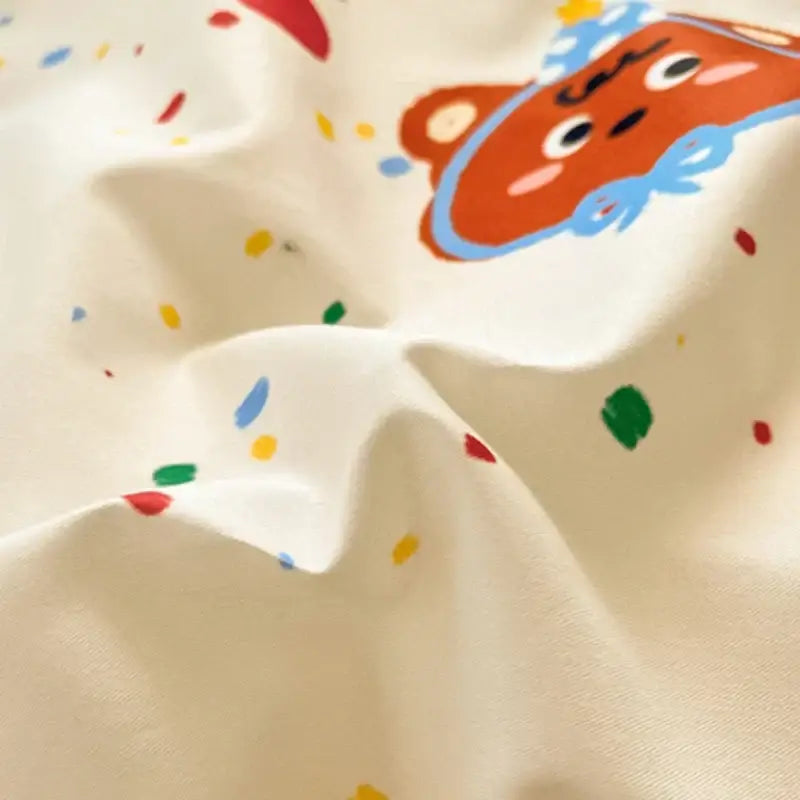Cream-colored cartoon printed cotton duvet cover featuring a playful bear with blue outlines and multicolored confetti dots