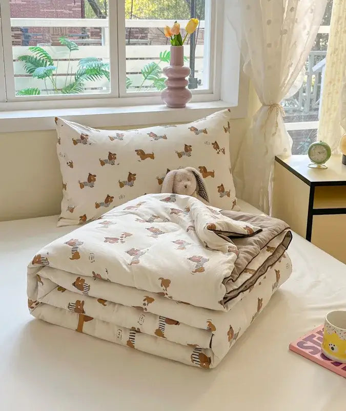A cream cooling blanket with a decorbites cartoon printed pattern of dachshunds for summer bedroom use