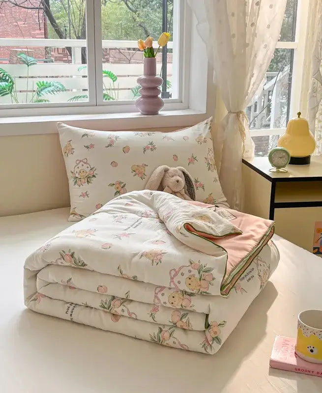 A cream-colored cooling blanket with delicate floral and bunny decorbites cartoon printed design for summer use