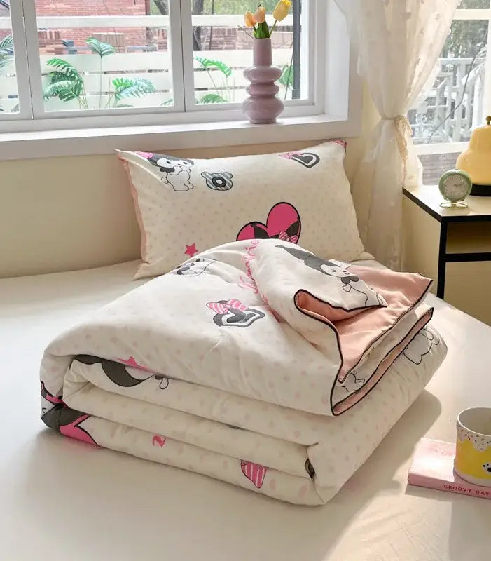 A cream cooling blanket with pink and black minnie mouse patterns and matching pillow for cartoon printed summer use
