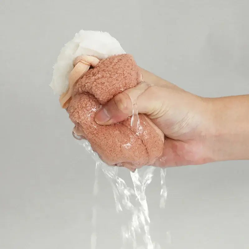 A soft pink coral fleece hand towel with a white cloth top featuring decorbites cartoon rabbit design