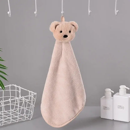A blush-pink plush hand towel with a cartoon rabbit head and black embroidered eyes made of coral fleece terry cloth