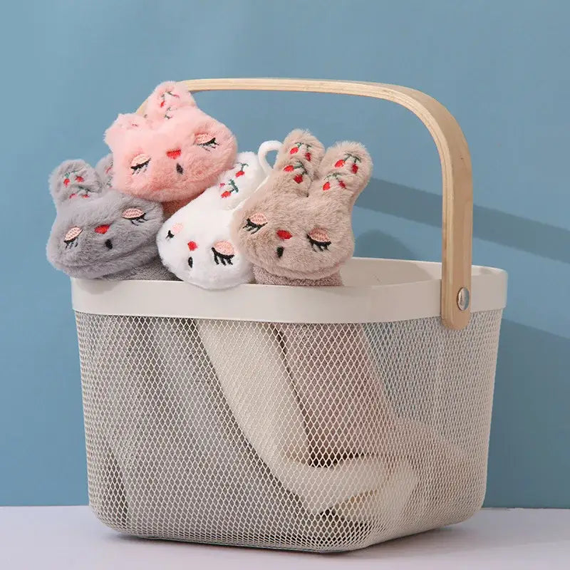 A beige mesh basket with wooden handle holds plush bunny socks in pink gray and white for decorbites cartoon rabbit coral hand towel decor
