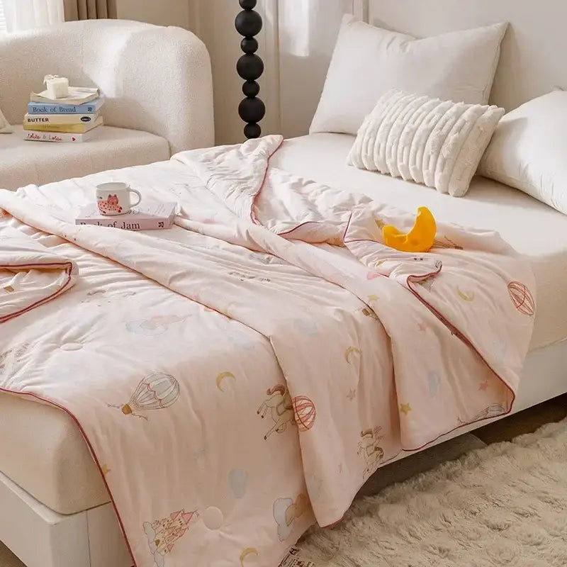 Pink quilted cooling summer blanket with whimsical hot air balloons horses and moons for bedroom use
