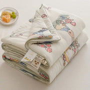 A soft off white cooling summer blanket featuring a cartoon rabbit design with pastel flowers and foliage