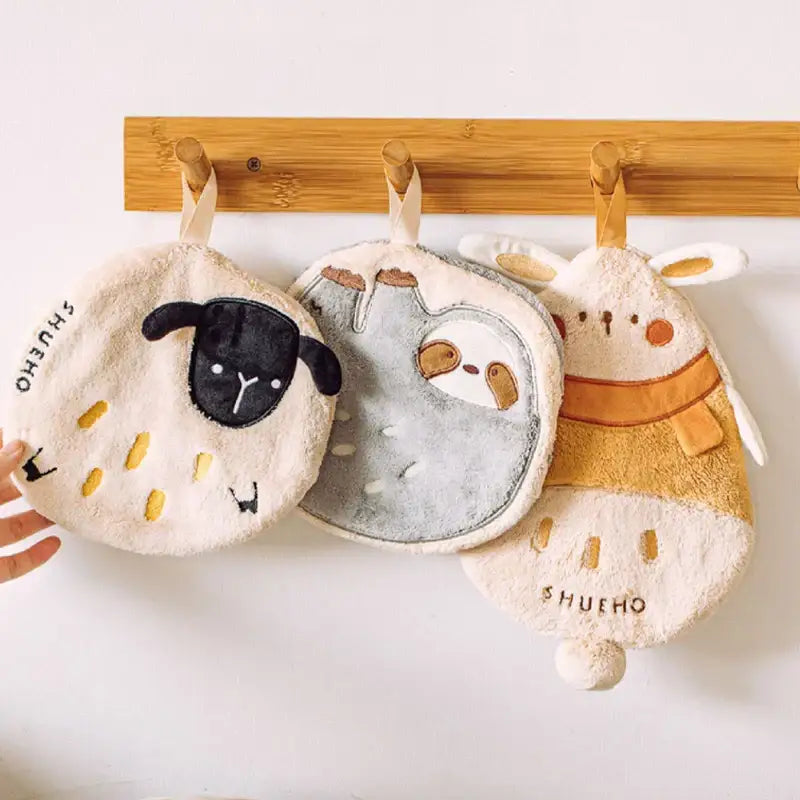 Three plush cartoon sloth hand towels in cream gray and beige with sheep sloth and rabbit embroidered faces decorbites cartoon sloth