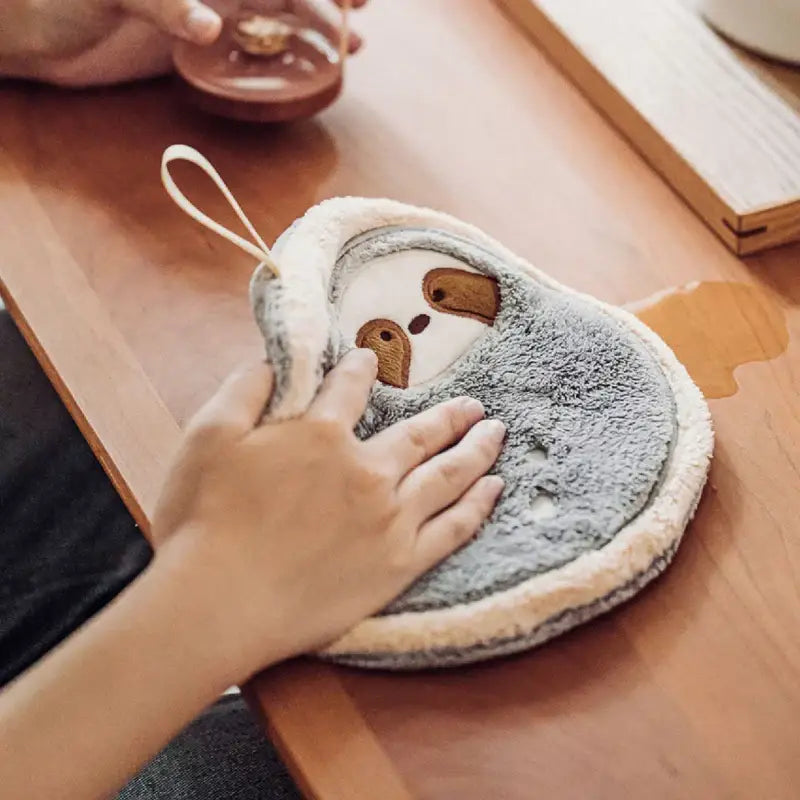 Gray and cream plush decorbites cartoon sloth hand towels featuring embroidered facial details in a three piece dishcloth set