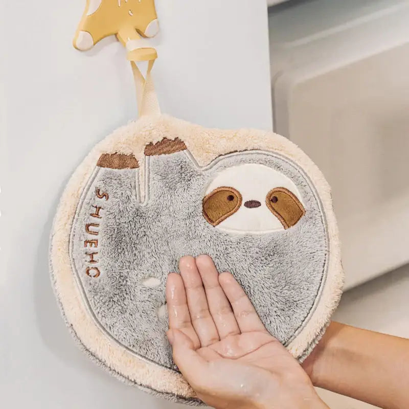 A soft plush gray and cream decorbites cartoon sloth hand mitt with embroidered eyes for cartoon sloth hand towels