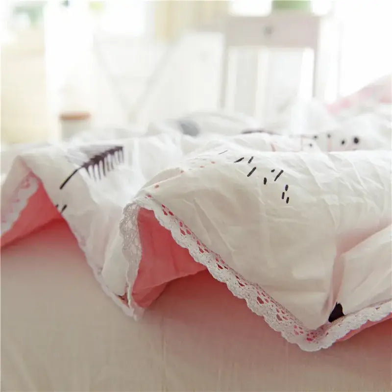 Delicate white lace-trimmed quilted double blanket with soft pink lining and subtle black embroidery for bedroom use