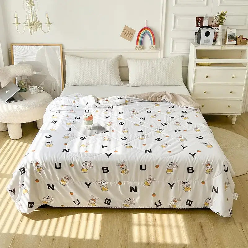 White quilted double blanket with playful cartoon bunnies black letters and orange dots for bedroom use