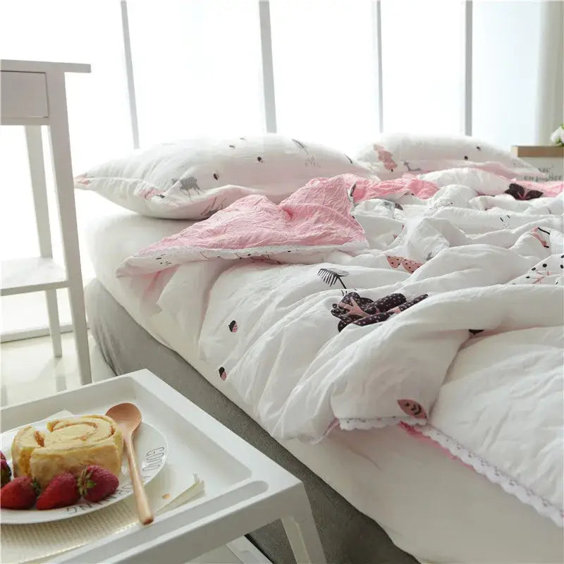 White and pink quilted double blanket with playful animal prints and lace trim for bedroom use