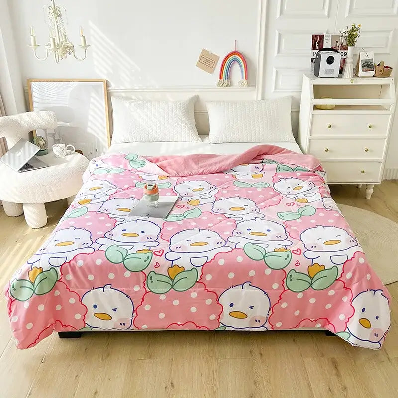 Pink quilted double blanket featuring white cartoon ducks with orange beaks and green leaves on a polka dot background