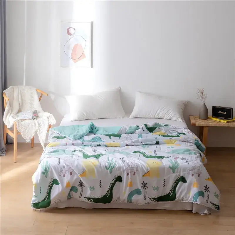 A cozy white quilted double blanket with playful green and teal dinosaurs, palm trees, and yellow suns on light background