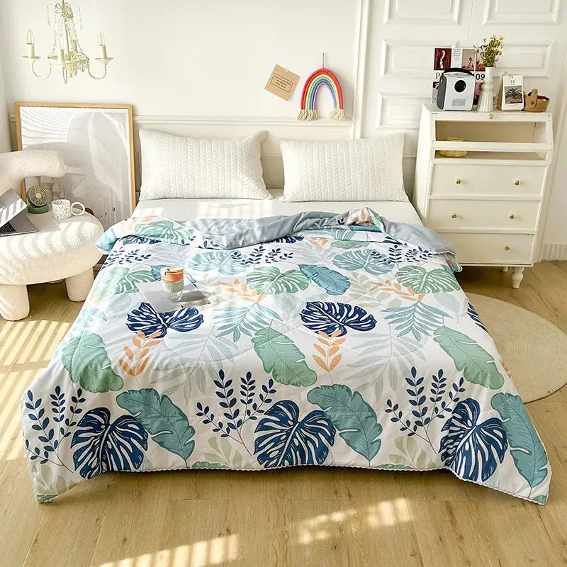 A cozy quilted double blanket with a white pink cartoon strawberry design and a vibrant tropical leaf pattern in blue green and orange